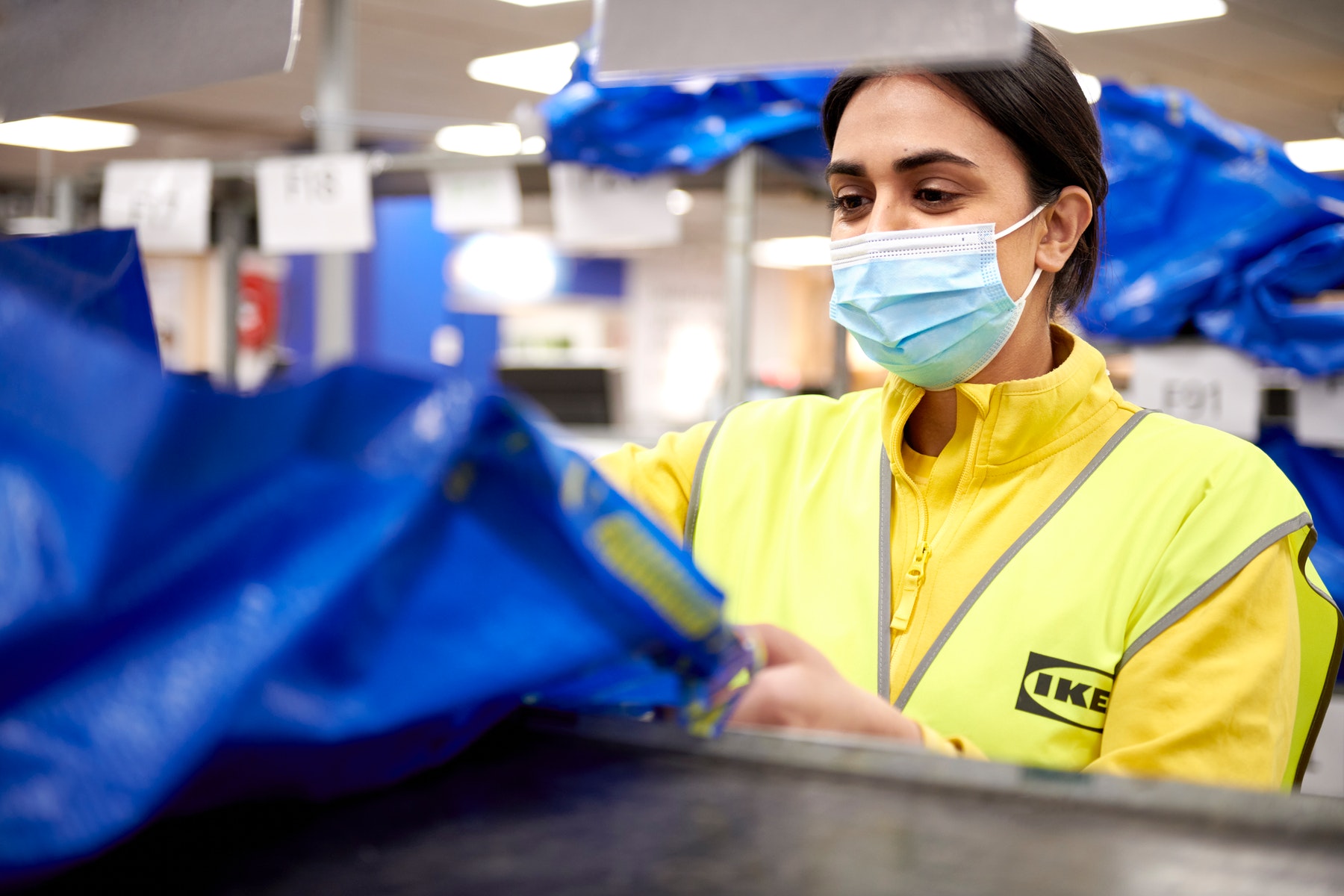Happy IKEA employee wearing a mask for protection
